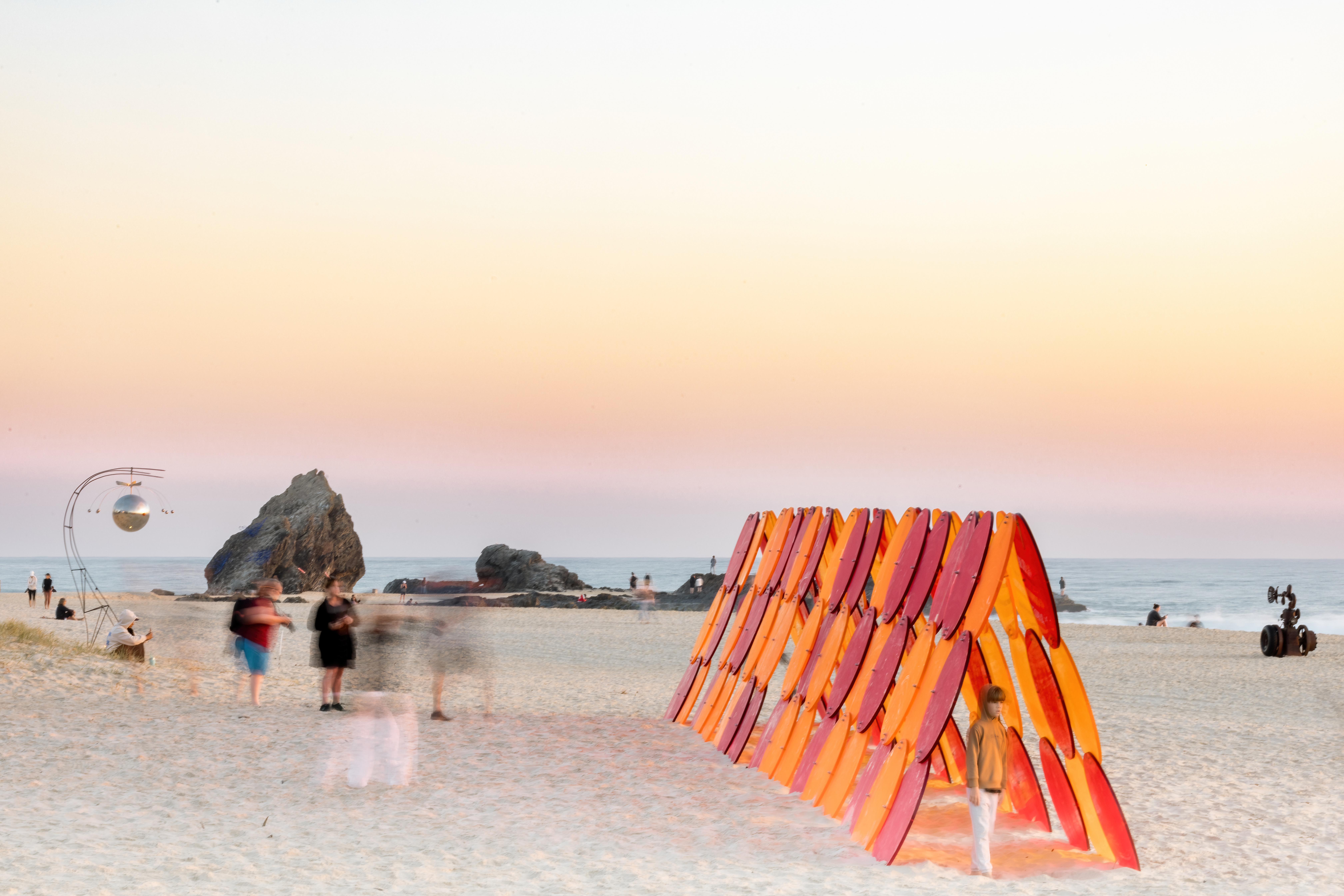 People enjoying the SWELL Sculpture Festival on the beach. 